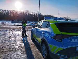 obraz przedstawia radiowóz i policjanta